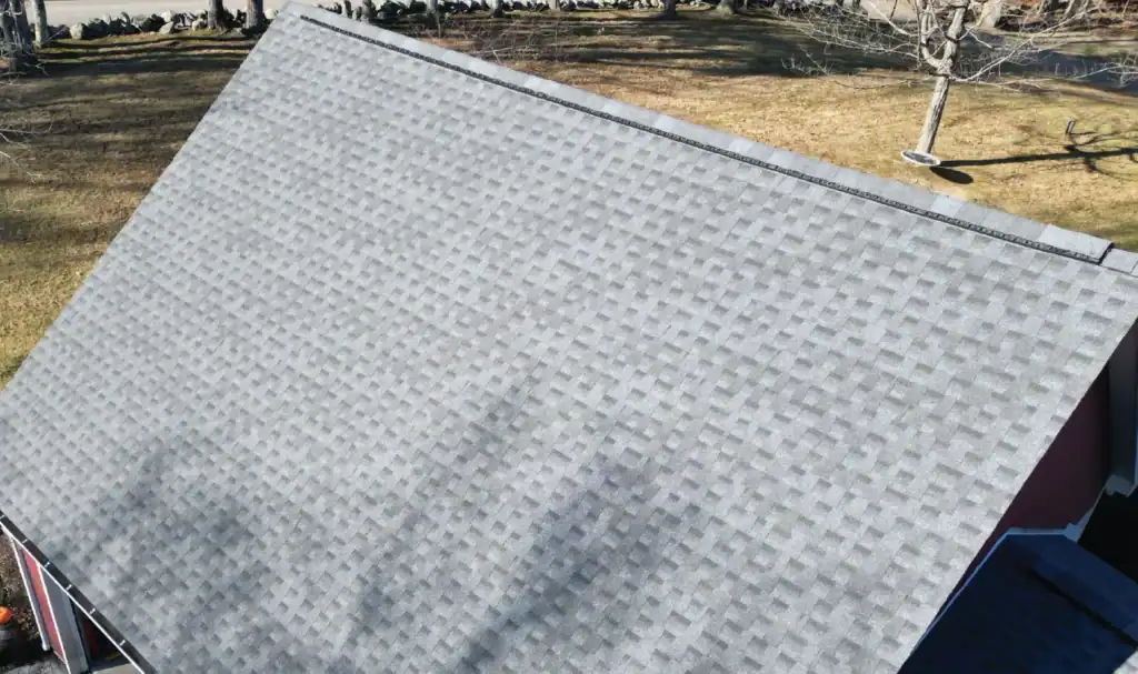Finished gray architectural shingle roof installed by J. Carnes & Son Roofing in New Hampshire, with a continuous ridge vent running along the peak for attic ventilation