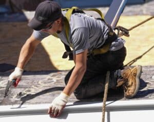 J. Carnes & Son Roofing crew member in a safety harness installing a roof on a New Hampshire Seacoast home