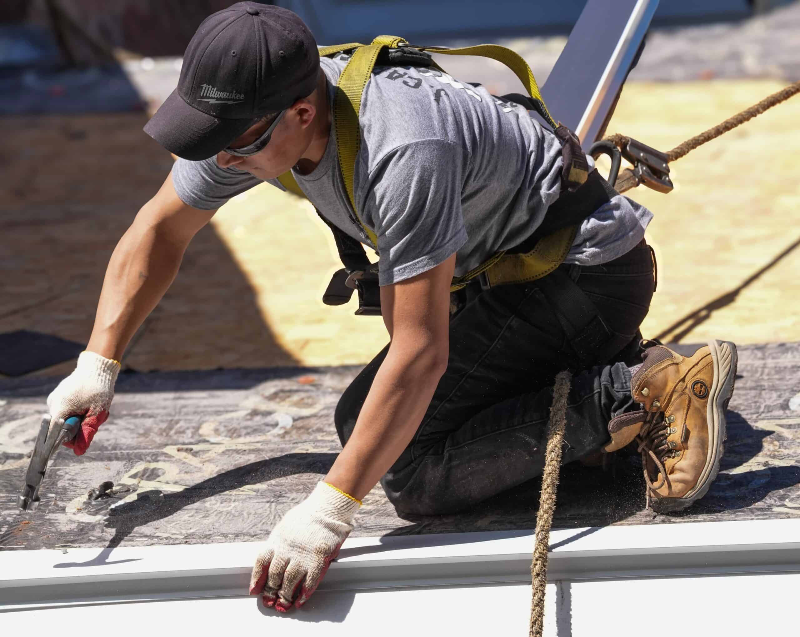 J. Carnes & Son Roofing crew member in a safety harness installing a roof on a New Hampshire Seacoast home